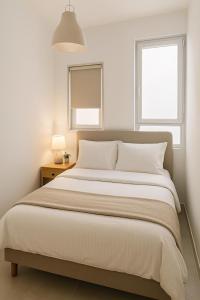 a bedroom with a large bed and two windows at Sweet apartment in Netanya