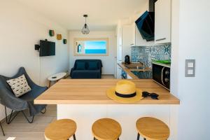 cocina y sala de estar con mesa y sombrero en "PLAGE" Splendide Vue Mer depuis la chambre et le salon cuisine, 20m de la plage!, en Canet-en-Roussillon