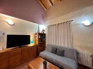 un soggiorno con divano e TV a schermo piatto di Casa Rural Hoces del Cabriel a Villargordo del Cabriel