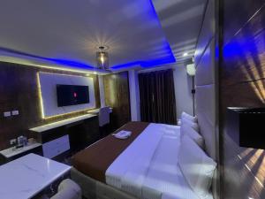 una camera d'albergo con un letto e una TV di Presken Hotel (Reliance) a Ikeja