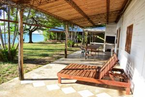 a wooden bench sitting on the porch of a house at Atardecer Cabaña frente al rio in Ituzaingó