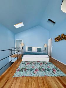 Dormitorio azul con cama y alfombra en Casas do Teatro, en Oporto