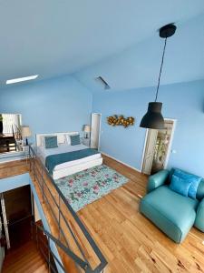 Dormitorio azul con cama y sofá en Casas do Teatro, en Oporto