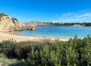 een uitzicht op een strand met rotsen in het water bij Villa Tres in Es Mercadal