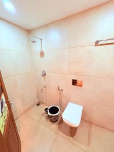 ein Bad mit Dusche, WC und Eimer in der Unterkunft Athirappilly Heritage Villa - 2BHK -River Side in Athirappilly + 21 Fotos