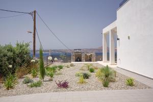 a house with a garden with plants in front of it at Luxury Villa Apeiro in Plaka in Plaka