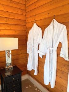 two white robes hanging on a wall in a room at Kaoglen-Stags-Hot tub-Cairngorms-Pet Friendly in Balnald