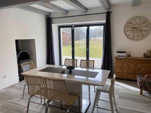 a dining room with a table and chairs and a clock at Homeland - family friendly house in Ledce