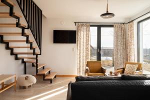 a living room with a staircase and a couch at Domki Szczyt Beztroski - Balia & Sauna in Nowy Targ