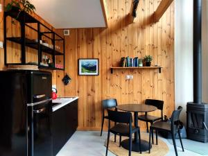 a kitchen with wooden walls and a table and chairs at Przyjedź Tutaj in Maków Mazowiecki