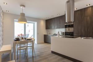 a kitchen with a counter and a table with chairs at Akicity Santarém Rock in Santarém
