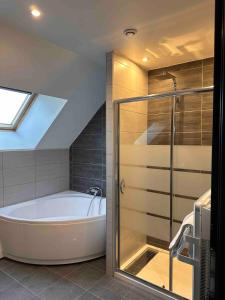 a bathroom with a bath tub and a shower at Charmante maison de ville aux portes de Dole in Crissey
