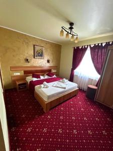 a hotel room with two beds and a red carpet at MOTEL COOL in Bărcăneşti