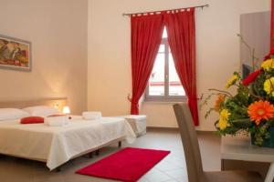 a bedroom with two beds and a window with red curtains at Villa Cavalleri in Gattinara