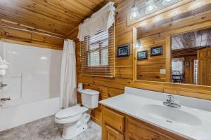 a bathroom with a toilet and a sink and a tub at Cloud Nine at Sherwood Forest in Pigeon Forge