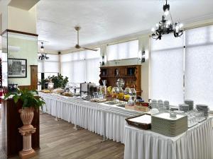 eine Buffetlinie mit weißen Tischen in einem Restaurant in der Unterkunft Dom Dinis in Trancoso