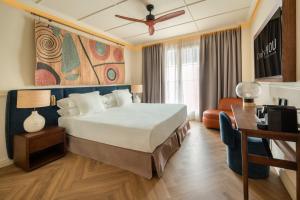 a hotel room with a bed and a couch at Only YOU Hotel Sevilla in Seville