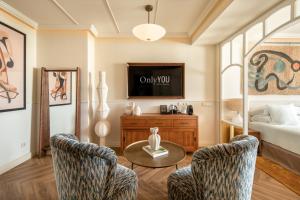 a living room with a tv and a bed at Only YOU Hotel Sevilla in Seville