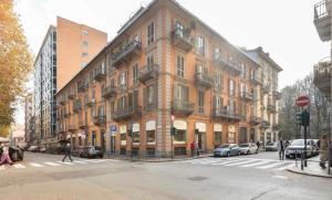a large brick building with cars parked in front of it at Casa vacanze Il Gianduiotto in Turin