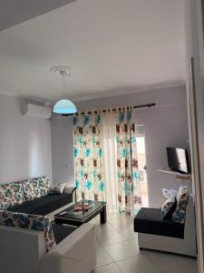 a living room with a couch and a table at Mateos Apartment Saranda in Sarandë