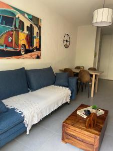 a living room with a blue couch and a table at Charmant appart. 3-4 pers. in Saleilles