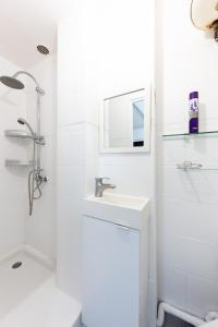 a white bathroom with a sink and a mirror at Hyper Centre Villejuif à côté du M7 proche de Paris in Villejuif
