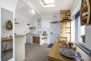 a kitchen with a table with a plate of food on it at Meads Cabin in Charmouth +17 photos