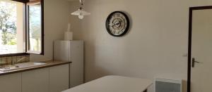 a kitchen with a refrigerator and a clock on the wall at Au fief du château in Airvault +19 photos