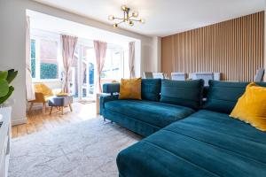 a living room with a blue couch in a room at Modern and Spacious Home From Home 1 mile from M1 - with Netflix, Prime Video, PS5, free parking, superfast WiFi, BBQ - Sleeps 11 - By Brightleap Apartments in Milton Keynes