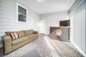 a living room with a couch and a flat screen tv at Walk to Lake Erie and Beach Access Home with Deck! in Erie