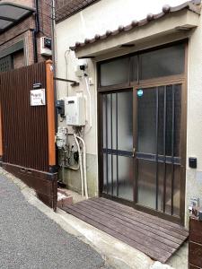a front door of a building with a wooden porch at 子猫の家 103t in Tokyo