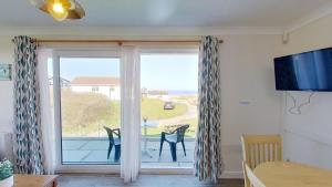 a room with a window with a view of the ocean at D20 Glendon, Riviere Towans in Hayle