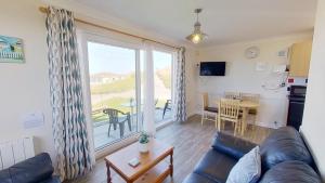 a living room with a couch and a table at D20 Glendon, Riviere Towans in Hayle