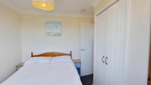 a bedroom with a bed with a wooden head board at D20 Glendon, Riviere Towans in Hayle