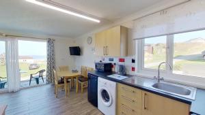 a kitchen with a sink and a washing machine at D20 Glendon, Riviere Towans in Hayle +9 photos