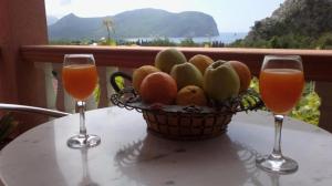 a basket of fruit on a table with two glasses at Vila Marina in Buljarica