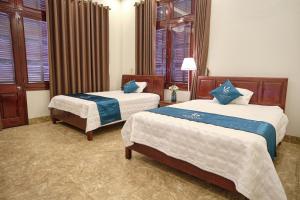 下龙湾Kim's Family Hotel的酒店客房带两张床和窗户