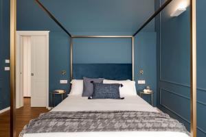 una camera da letto con un grande letto con pareti blu di Elysium Boutique Apartments - Catania a Catania