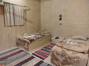 a room with two beds and a rug at Wenarose house in Siwa