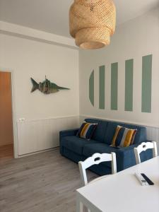 a living room with a blue couch and a fish on the wall at La Corte Dei Mari Acquamarina in Cesenatico +8 photos