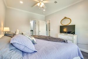 a bedroom with a bed with a ceiling fan and a tv at 1 Mi to Beach Access Home with Porch in Fort Myers! in Fort Myers