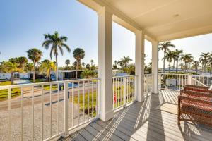 a porch with a bench and palm trees at 1 Mi to Beach Access Home with Porch in Fort Myers! in Fort Myers