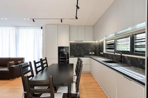 a kitchen with a black table and chairs in a room at SanPietro Premium Villas in Draç
