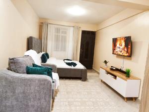 a living room with a couch and a bed at Staycation by Winnie-NAIPOSHA STUDIOS in Naivasha