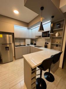 a kitchen with a table and a refrigerator at Departamento en Ibarra, Cerca a todo in Ibarra +8 photos