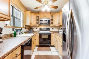 a kitchen with wooden cabinets and a stainless steel refrigerator at 3 Mi to Dtwn New Haven Colorful Condo with Yard! in West Haven