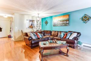 a living room with a leather couch and a table at 3 Mi to Dtwn New Haven Colorful Condo with Yard! in West Haven