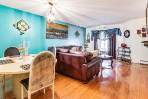 a living room with a leather couch and a table at 3 Mi to Dtwn New Haven Colorful Condo with Yard! in West Haven