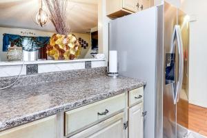 a kitchen with a refrigerator and a counter at 3 Mi to Dtwn New Haven Colorful Condo with Yard! in West Haven