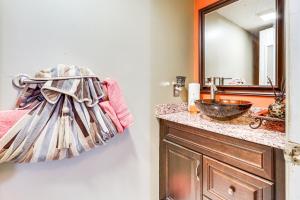 a bathroom with a sink and a towel hanging on the wall at 3 Mi to Dtwn New Haven Colorful Condo with Yard! in West Haven